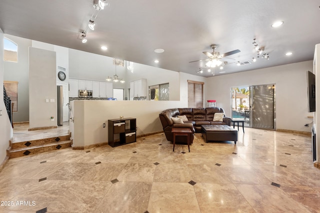 living room featuring ceiling fan with notable chandelier and track lighting