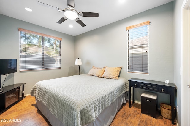 bedroom with multiple windows, wood-type flooring, and ceiling fan