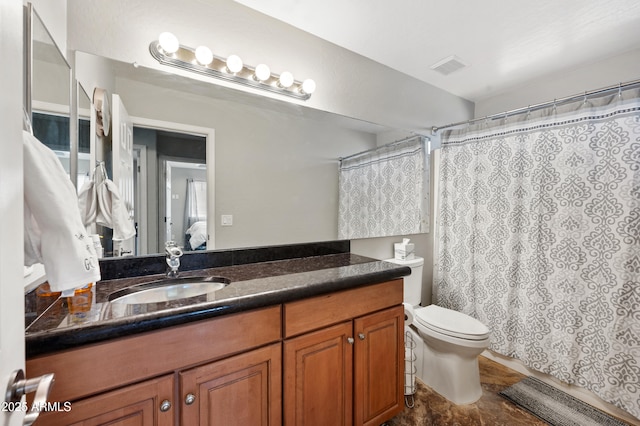 bathroom featuring walk in shower, vanity, and toilet