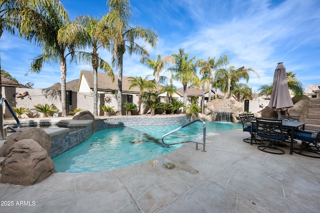 view of swimming pool with pool water feature and a patio area