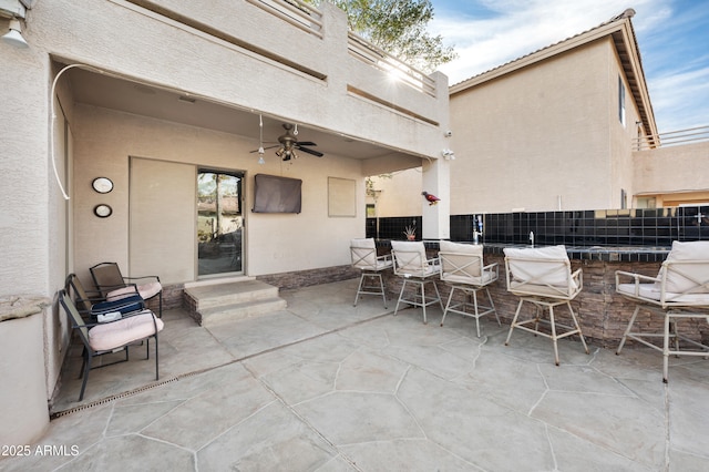 view of patio / terrace with an outdoor bar and ceiling fan