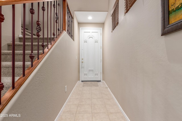 doorway with stairs, tile patterned flooring, and baseboards