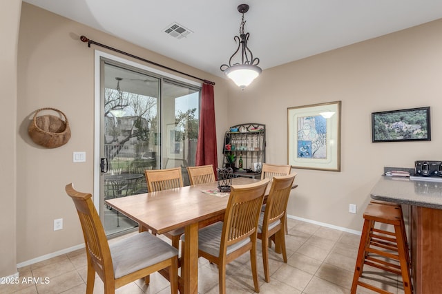 dining room featuring light tile patterned floors, visible vents, and baseboards