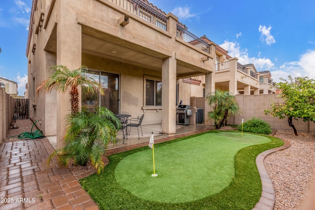 rear view of house with a fenced backyard, a patio, and stucco siding