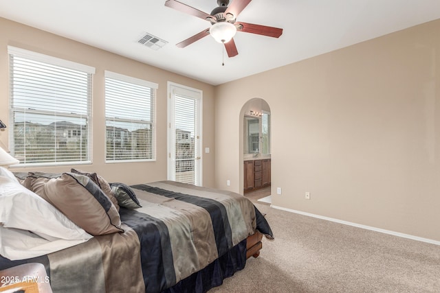 bedroom featuring arched walkways, light colored carpet, visible vents, a ceiling fan, and baseboards