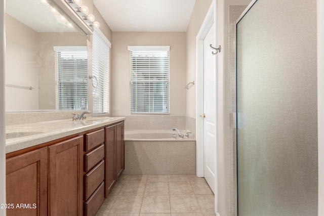 bathroom with a garden tub, a sink, tile patterned floors, double vanity, and a stall shower