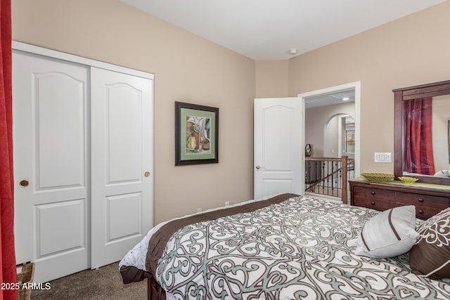 bedroom featuring arched walkways, a closet, and carpet