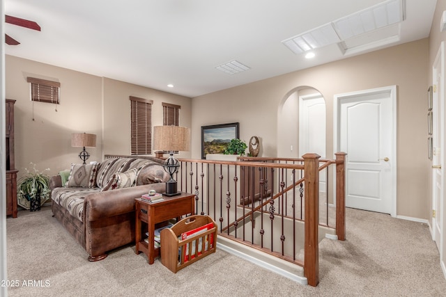 living room with arched walkways, recessed lighting, carpet flooring, visible vents, and baseboards