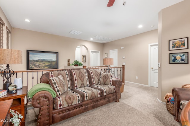 carpeted living area featuring baseboards, visible vents, arched walkways, ceiling fan, and recessed lighting