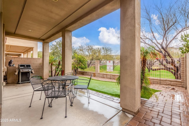 view of patio featuring outdoor dining space, a fenced backyard, and a grill