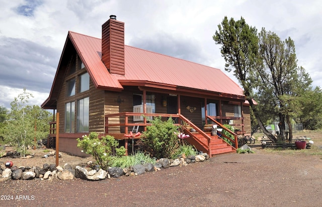 log-style house with covered porch