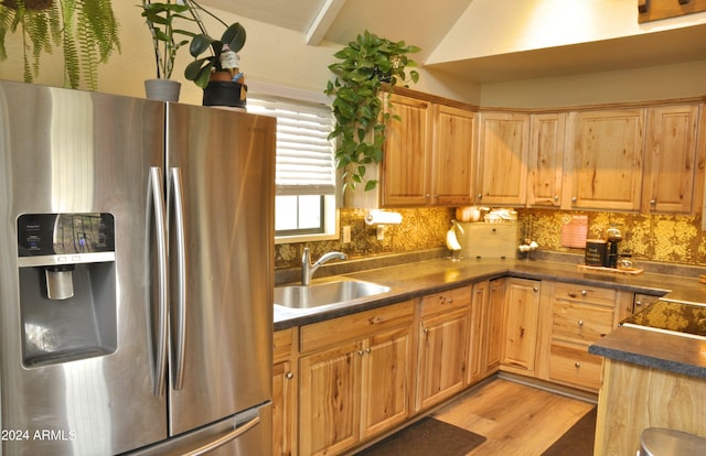 kitchen featuring decorative backsplash, stainless steel refrigerator with ice dispenser, light hardwood / wood-style floors, and sink