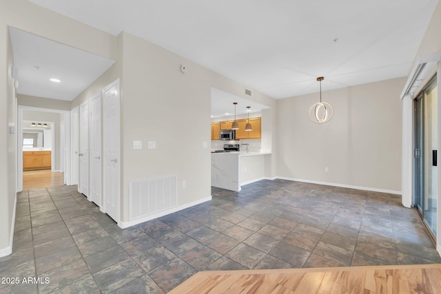 20121 N 76th St Unit 2021, Scottsdale, AZ 85255 - unfurnished living room with baseboards and stone tile floors