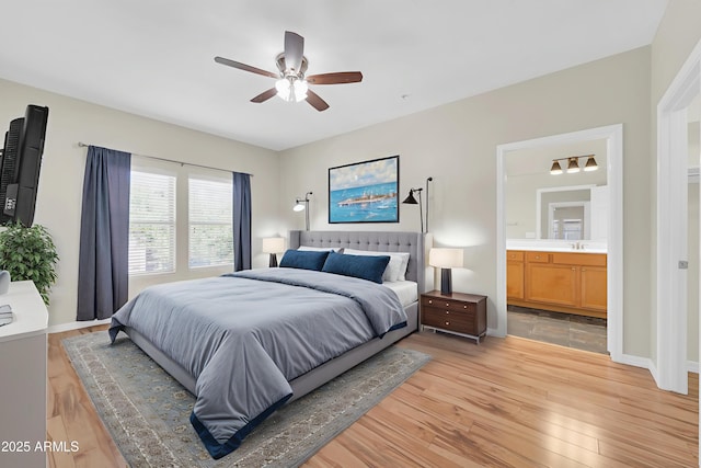 20121 N 76th St Unit 2021, Scottsdale, AZ 85255 - bedroom with light wood finished floors, baseboards, connected bathroom, ceiling fan, and a sink