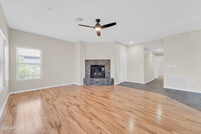 20121 N 76th St Unit 2021, Scottsdale, AZ 85255 - unfurnished living room featuring wood finished floors, a ceiling fan, baseboards, recessed lighting, and a tile fireplace