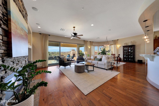 living area with dark wood-style floors, ceiling fan, visible vents, and recessed lighting