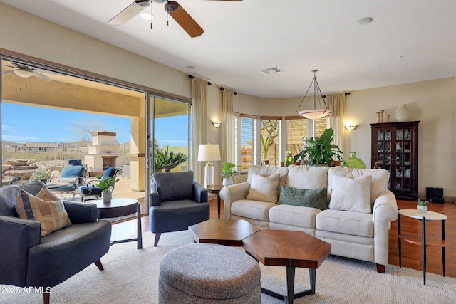 living area featuring ceiling fan and visible vents