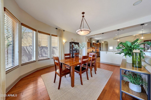 dining area featuring light wood-type flooring, baseboards, and a wealth of natural light