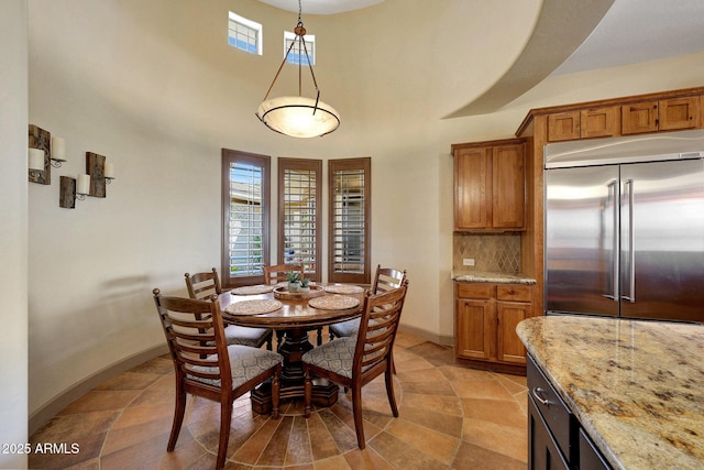 dining area with a high ceiling and baseboards