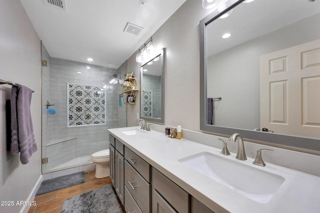 bathroom featuring wood finished floors, a sink, and visible vents