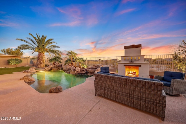 view of pool featuring a patio, an outdoor living space with a fireplace, and a fenced backyard