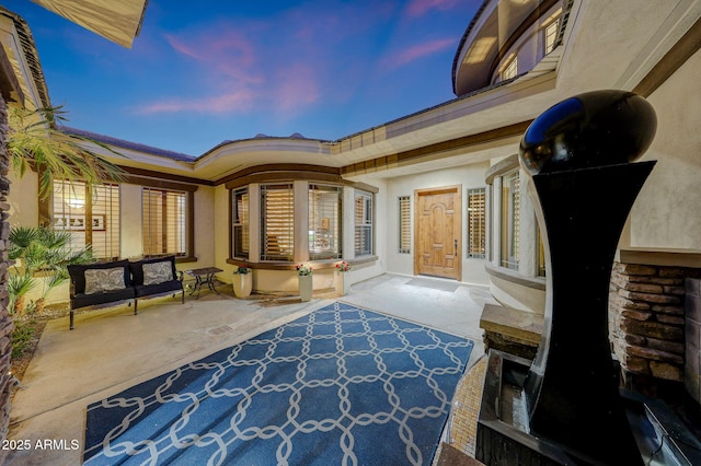 patio terrace at dusk featuring an outdoor living space