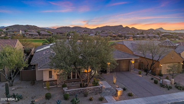 view of front of house with concrete driveway, a mountain view, an attached garage, and stucco siding