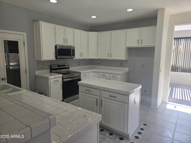 955 W Laurel Ave, Gilbert, AZ 85233 - kitchen with stainless steel appliances, tile counters, white cabinets, a kitchen island, and recessed lighting