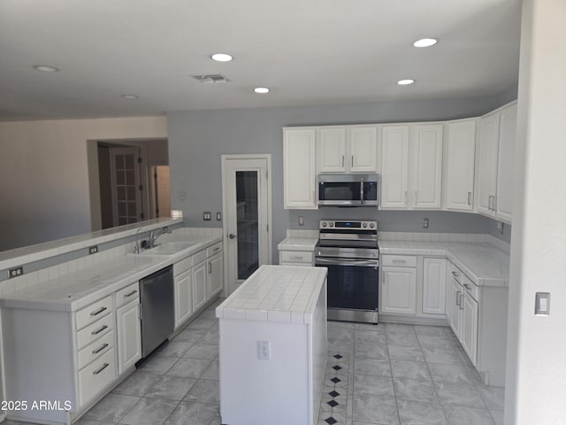 955 W Laurel Ave, Gilbert, AZ 85233 - kitchen featuring stainless steel appliances, tile countertops, a peninsula, white cabinets, and recessed lighting