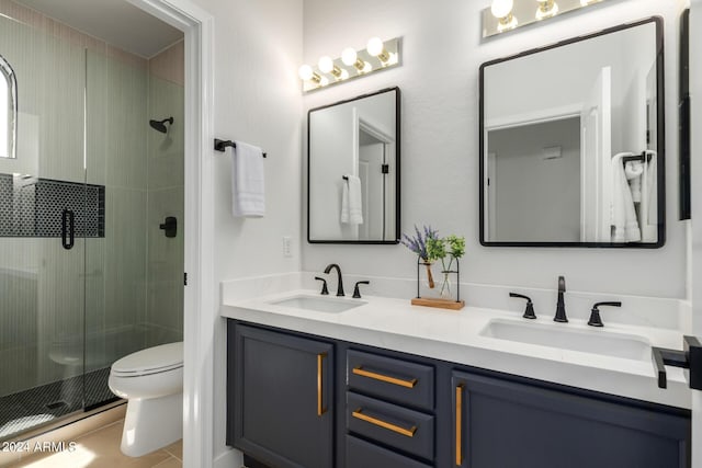 bathroom featuring toilet, a shower with shower door, vanity, and tile patterned flooring