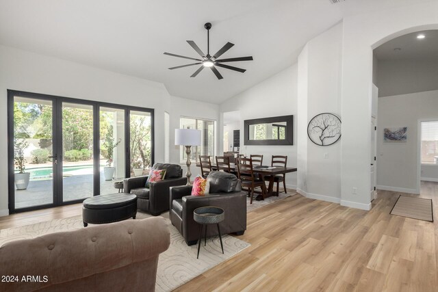 living room featuring ceiling fan, light wood-type flooring, and high vaulted ceiling