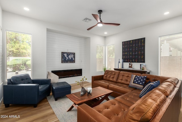 living room with ceiling fan, light wood-type flooring, and a wealth of natural light