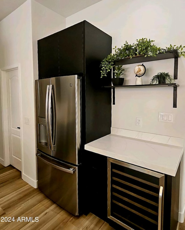 kitchen with light hardwood / wood-style flooring, wine cooler, and stainless steel refrigerator with ice dispenser