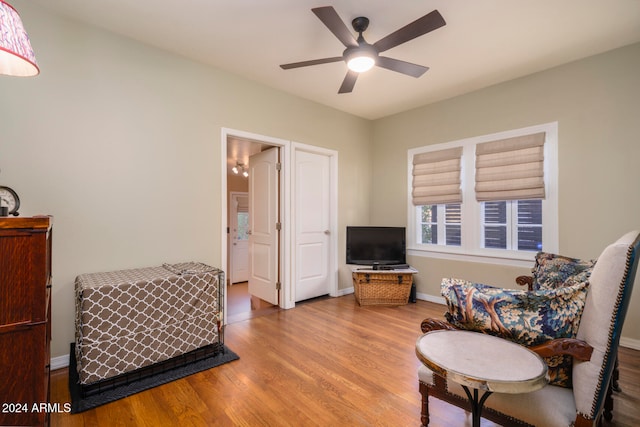 living area featuring hardwood / wood-style floors and ceiling fan