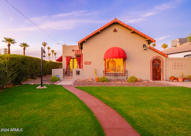 mediterranean / spanish-style home with a lawn