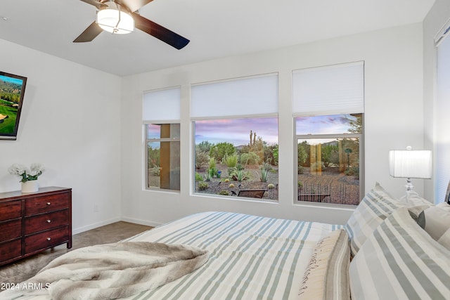 bedroom featuring multiple windows, ceiling fan, and light carpet