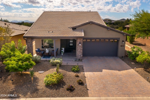 view of front of home with a mountain view, a garage, and a patio area