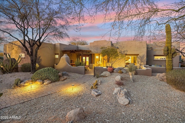 pueblo-style house with an outdoor hangout area and a patio