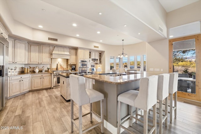 kitchen featuring hanging light fixtures, premium range hood, a large island, and stainless steel appliances