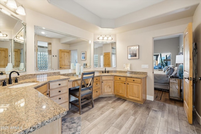 bathroom with hardwood / wood-style flooring, vanity, and a raised ceiling