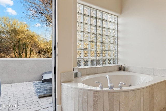 bathroom with a relaxing tiled tub