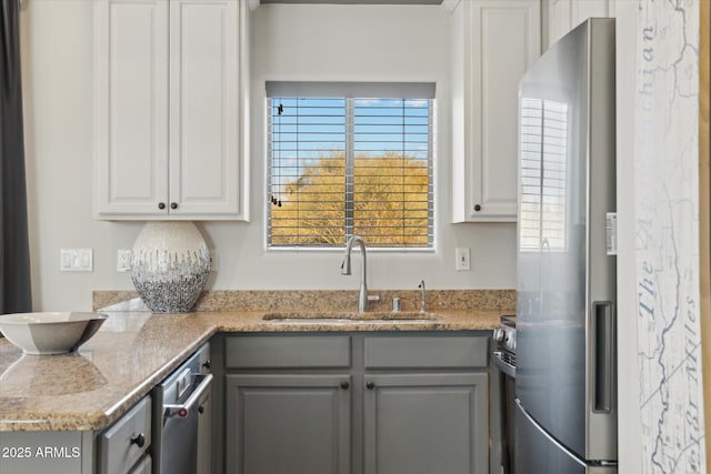 kitchen with sink, white cabinetry, fridge, gray cabinets, and stainless steel stove