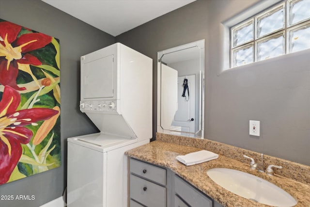 laundry room featuring stacked washer and dryer and sink