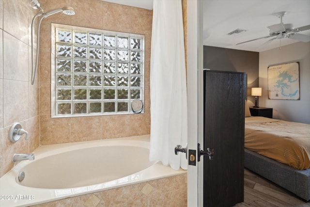 bathroom with wood-type flooring, shower / tub combo with curtain, and ceiling fan