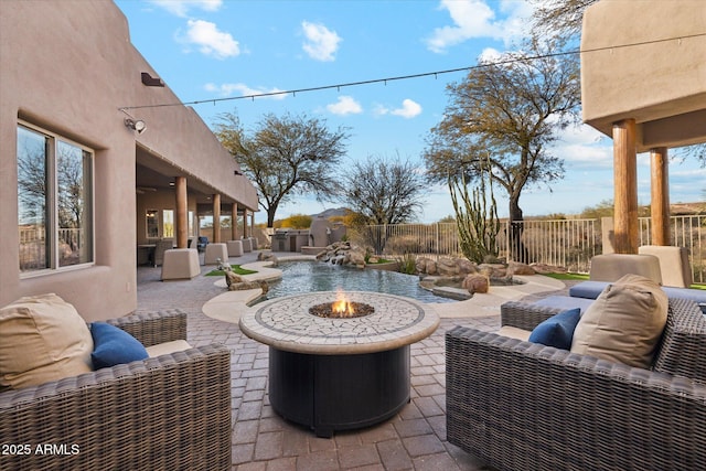 view of patio with an outdoor living space with a fire pit