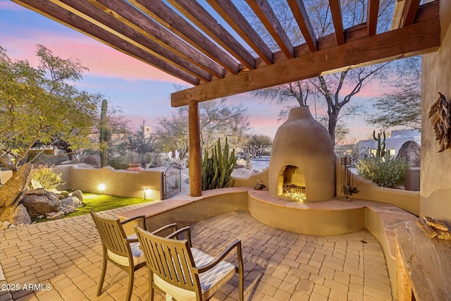 patio terrace at dusk with an outdoor fireplace