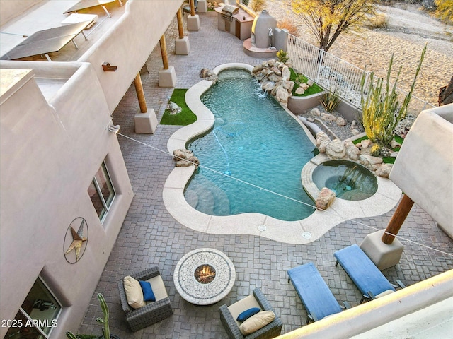 view of pool with an in ground hot tub and pool water feature