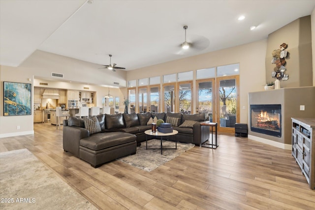 living room with ceiling fan and light hardwood / wood-style floors