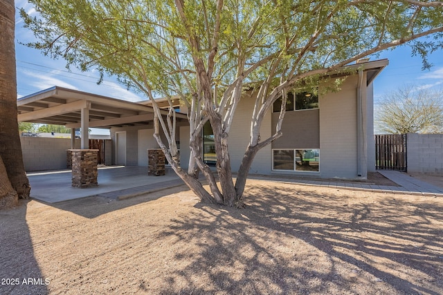 rear view of property featuring brick siding and fence