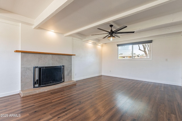 unfurnished living room with beamed ceiling, dark wood-style flooring, and baseboards